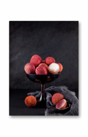 ripe, vermilion exotic lichees decorated on a slate plate kitchen table background with napkin