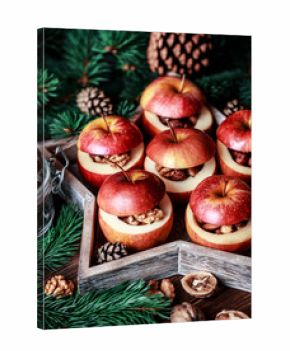 Baked apples with cinnamon on rustic background. Autumn or winter dessert. Closeup photo of a tasty baked apples with christmas decoration