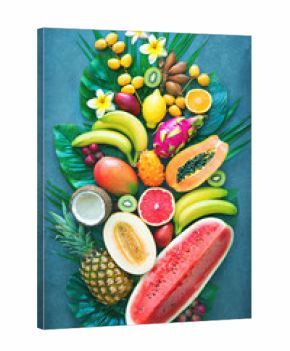 Assortment of tropical fruits with palm leaves and exotic flowers