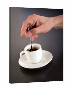 Hand Stirring Cup of Espresso Coffee with Spoon