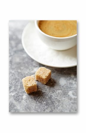 Two brown sugar cubes and a cup of coffee