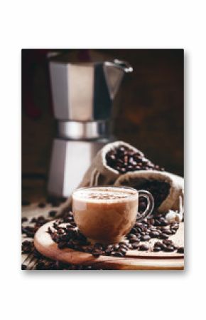 Coffee with milk in a glass cup, coffee beans in bags of canvas,