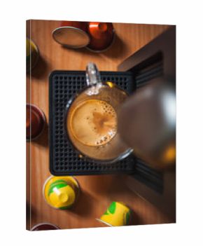 Vista dall'alto della macchina del caffè che fanno la tazza di caffè del mattino. capsule colorati sullo sfondo.