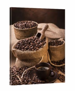 sacchi con chicchi di caffè e tazzina con espresso