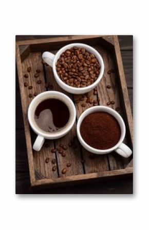Different types of coffee - ground, grain and beverage on dark wooden background, selective focus, vertical.