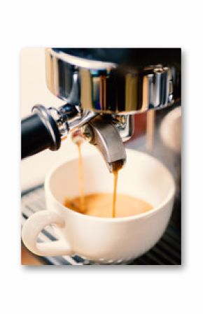 Coffee making, hot coffee flowing into a cup from espresso machine