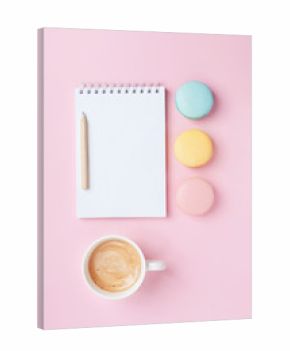 Empty notepad, coffee and colorful macaron on pink pastel desk top view. Cozy morning breakfast. Fashion flat lay. Sweet macaroons.
