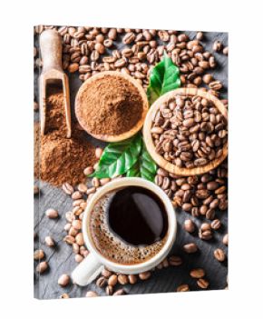 Roasted coffee beans, ground coffee and cup of coffee on wooden table.