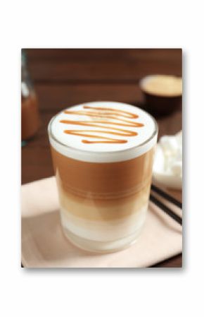 Glass with delicious caramel latte on table