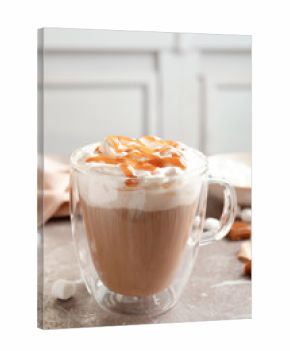 Cup of coffee with caramel topping on grey table