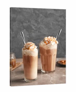 Glasses with delicious caramel frappe on table
