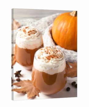 Glasses with tasty pumpkin spice latte on wooden table