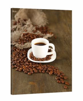 Cup of coffee and coffee beans on wooden background