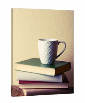 Old books and cup of coffee on table