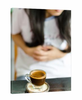 The woman drink coffee and make a stomachache.