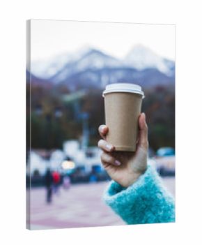 Girl's hand holding a cup of warming beverage with Mountain View