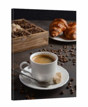 Cup of fresh coffee with croissants on dark background, selective focus