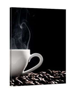 Steaming coffee cup put on coffee beans isolated on black background.