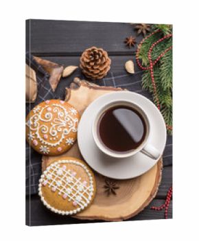 Cup of black coffee with Christmas gingerbread cookies on black 