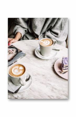 Female and man hands with cups of coffee on the background of a wooden table