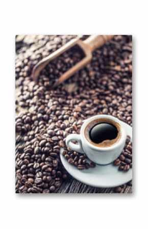 Cup of black coffee with beans on wooden table