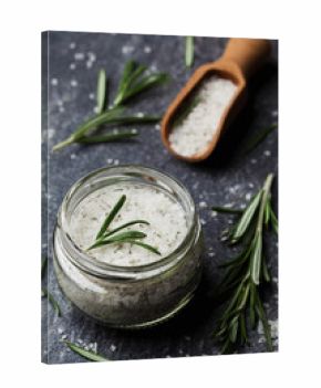 Sea salt scented herb rosemary on black stone background, vintage style