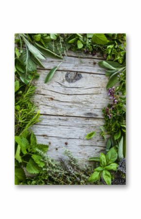 Fresh and aromatic herbs in frame on old wooden table. Space for text. 