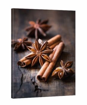 Traditional Christmas spices - Star anise with cinnamon and cloves on dark rustic wooden background