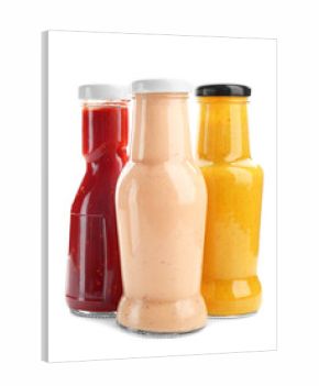 Bottles with different sauces for salad on white background