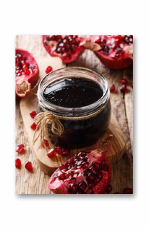 Homemade pomegranate sauce narsharab in a glass jar close-up. vertical