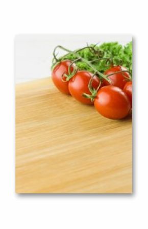 Tomatoes and parsley on chopping board against white background