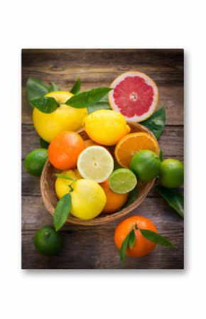 Fresh and juicy citrus fruits in the basket on the rustic table