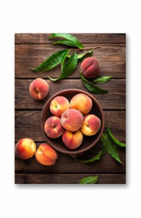 Fresh juicy peaches with leaves on dark wooden rustic background