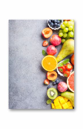 Fresh assorted fruits and berries on light gray background. Colorful clean and healthy eating. Detox food. Copy space. Top view.