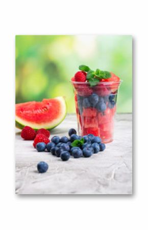Plastic cup full of fresh cut fruits and berries