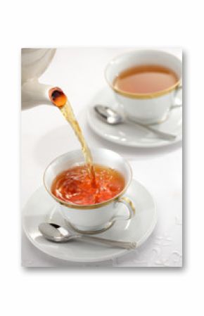 Pouring tea from the tea pot to the cups