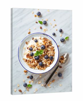 Cereals breakfast with blueberries on a marble background. Healthy morning meal with fresh berries. Top view