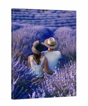 A couple is sitting in a field of lavender flowers