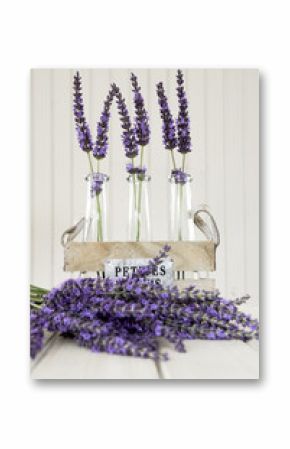 Three small vases with lavender on a white table