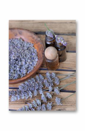essential oil from lavender  in bottle and  dried flowers in wooden bowl