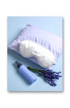 Soft purple pillow with satin sleep mask lavender flowers and skincare spray bottle on light blue background for relaxation sleep or beauty routine comfort and wellness