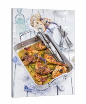 Traditional French braised lavender chicken with baguett bread served as close-up in a classic casserole