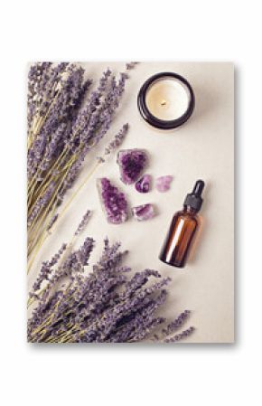 Glass bottle of Lavender essential oil with lavender flowers and candles and amethyst crystals. Meditation, zen, aromatherapy,spa massage concept