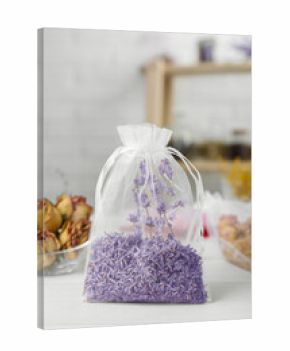 Scented sachet with dried lavender flowers on white table