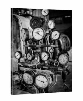 A lot of clocks and indicators in the historic device of the heat and power plant. black and white frame