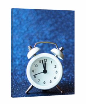 white alarm clock on a blue shiny background. copy space..