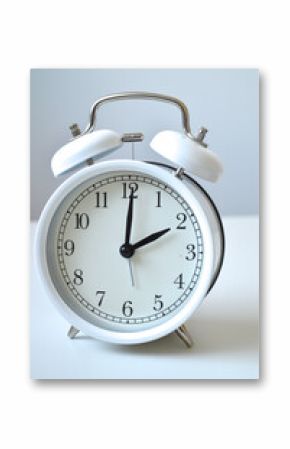 White vintage alarm clock showing 2 o'clock on clean minimalist background