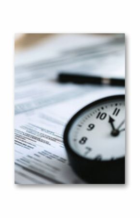 A minimalistic close-up of a black clock resting on a pile of papers, emphasizing time management and productivity in a professional setting
