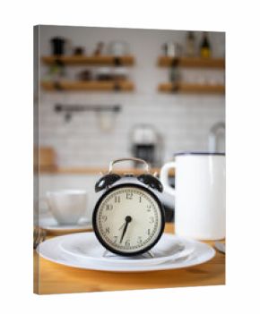 intermittent fasting concept alarm clock on kitchen table