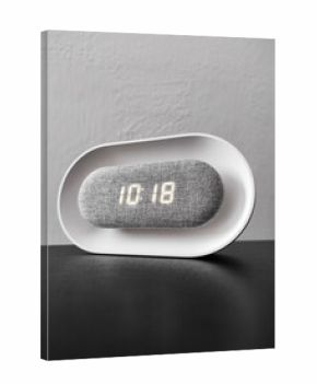 Digital white and modern clock on black table and white wall